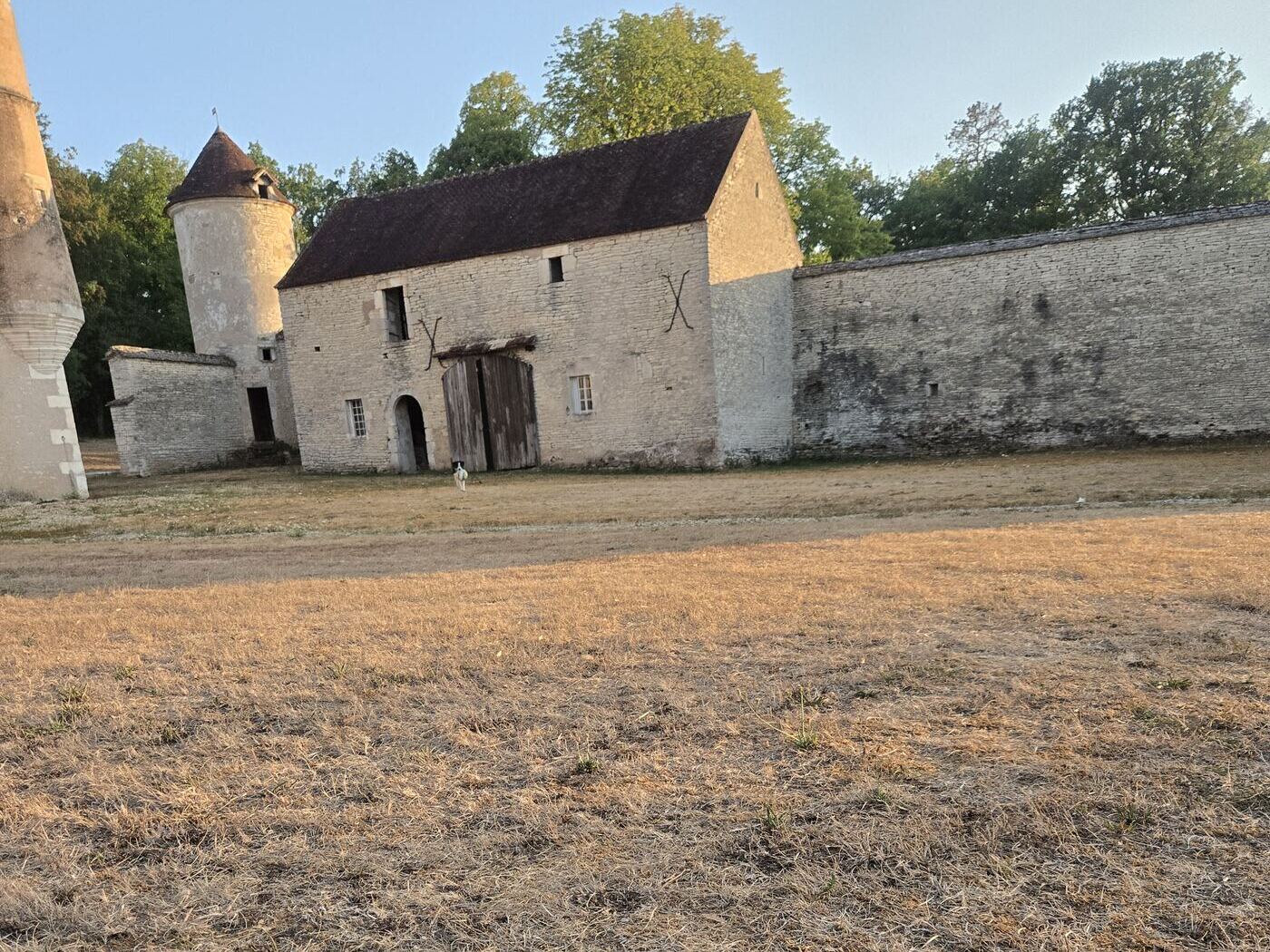 The barn with its X-shaped iron anchors, the round tower and the old enclosure wall